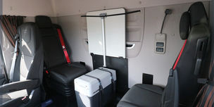 Une cabine de camion équipée de deux sièges perpendiculaires et d'aménagements modulables