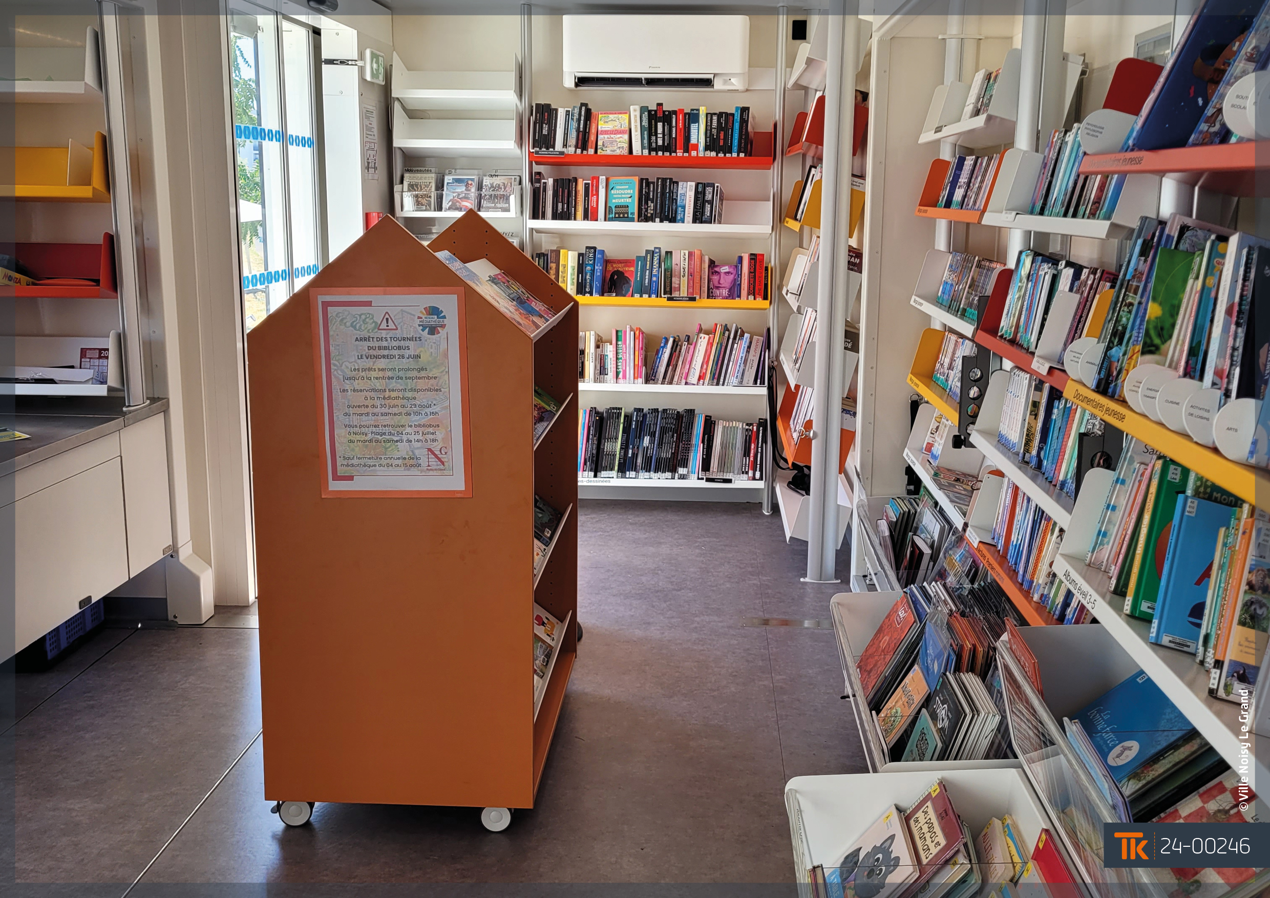 Intérieur d'une bibliothèque mobile avec étagères, espace de lecture et mobilier sur mesure